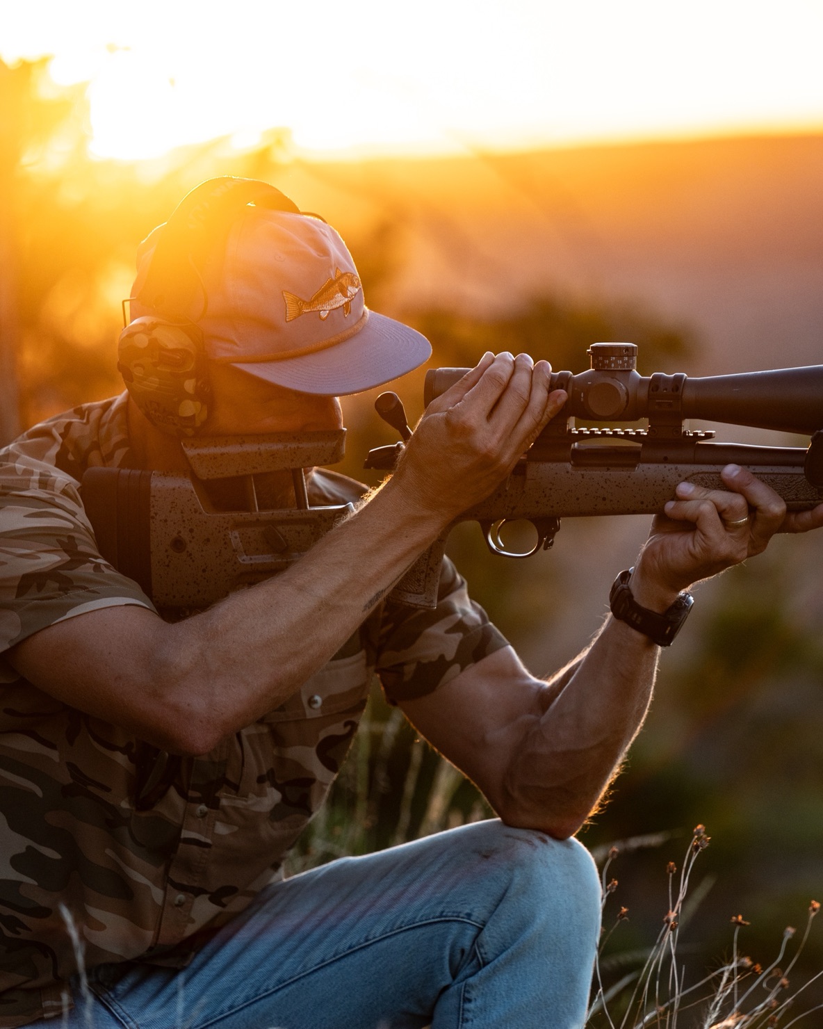 A member sighting in his rifle at golden hour on the mountain